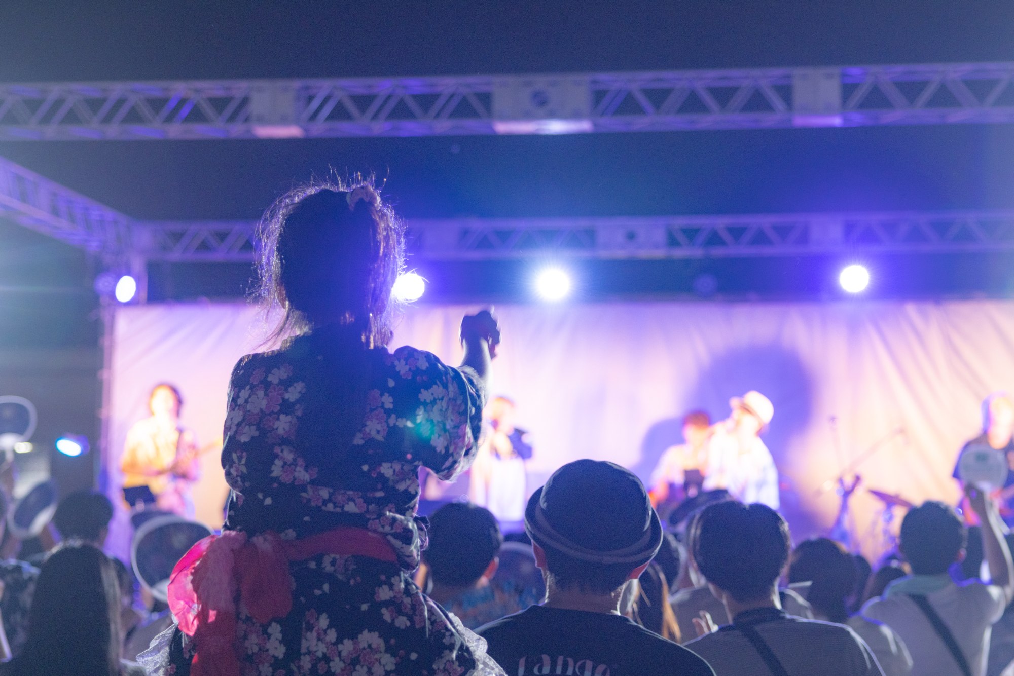 浴衣姿の来場者が見つめる夜のライブステージ